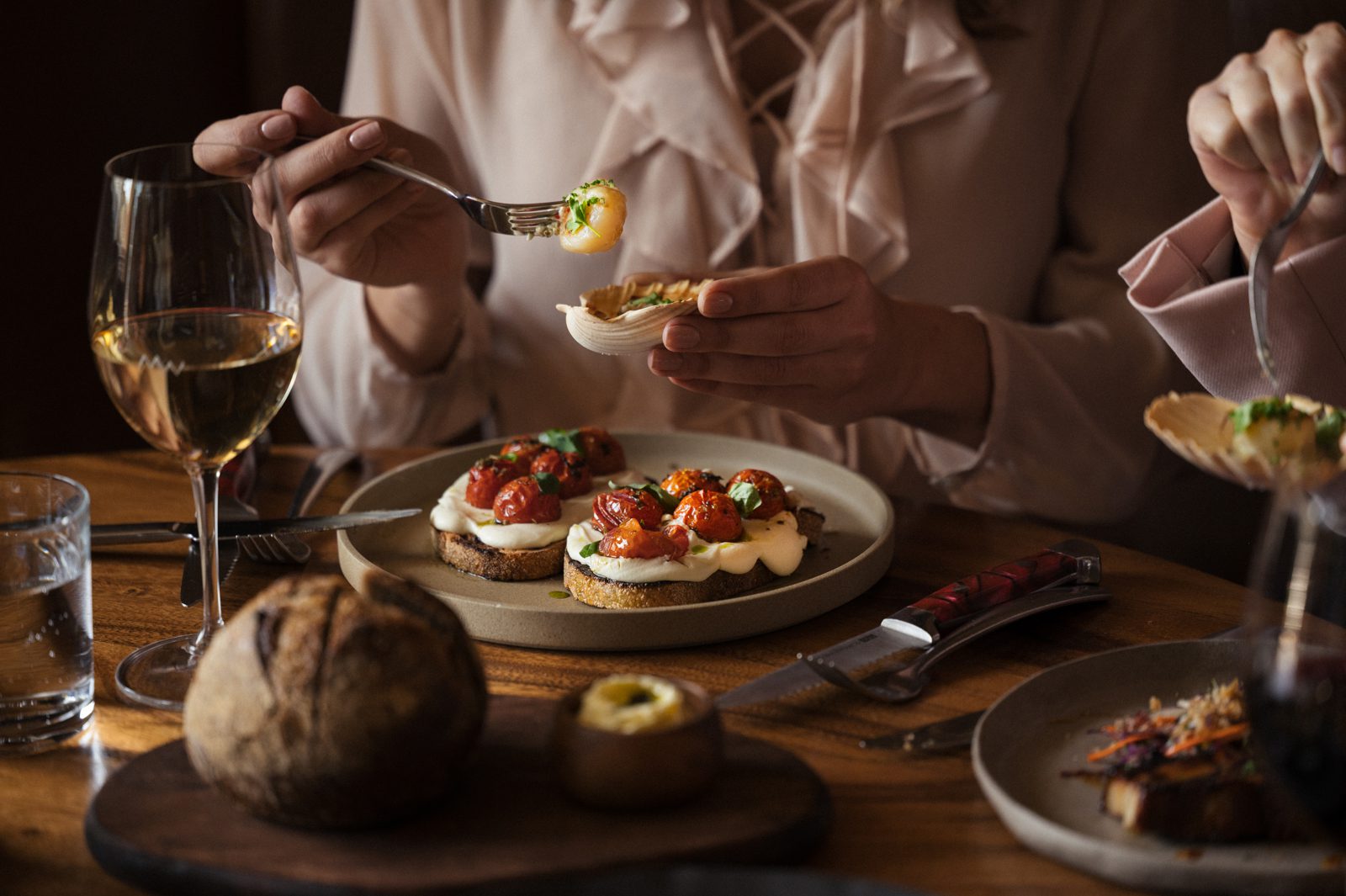 People enjoying baked scallops and bruschetta